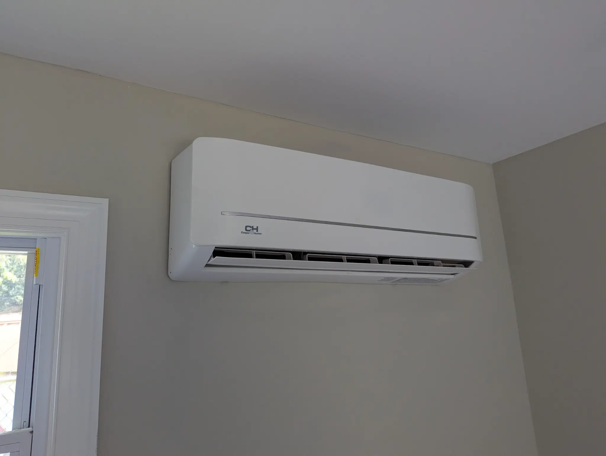 Wall-mounted ductless indoor comfort unit in a residential room